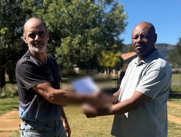 Two men shaking hands over a New Hope share certificate outdoors