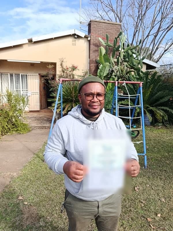 New Hope shareholder holding a certificate outdoors